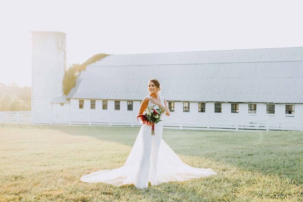 A bride in front of the white barn and silo