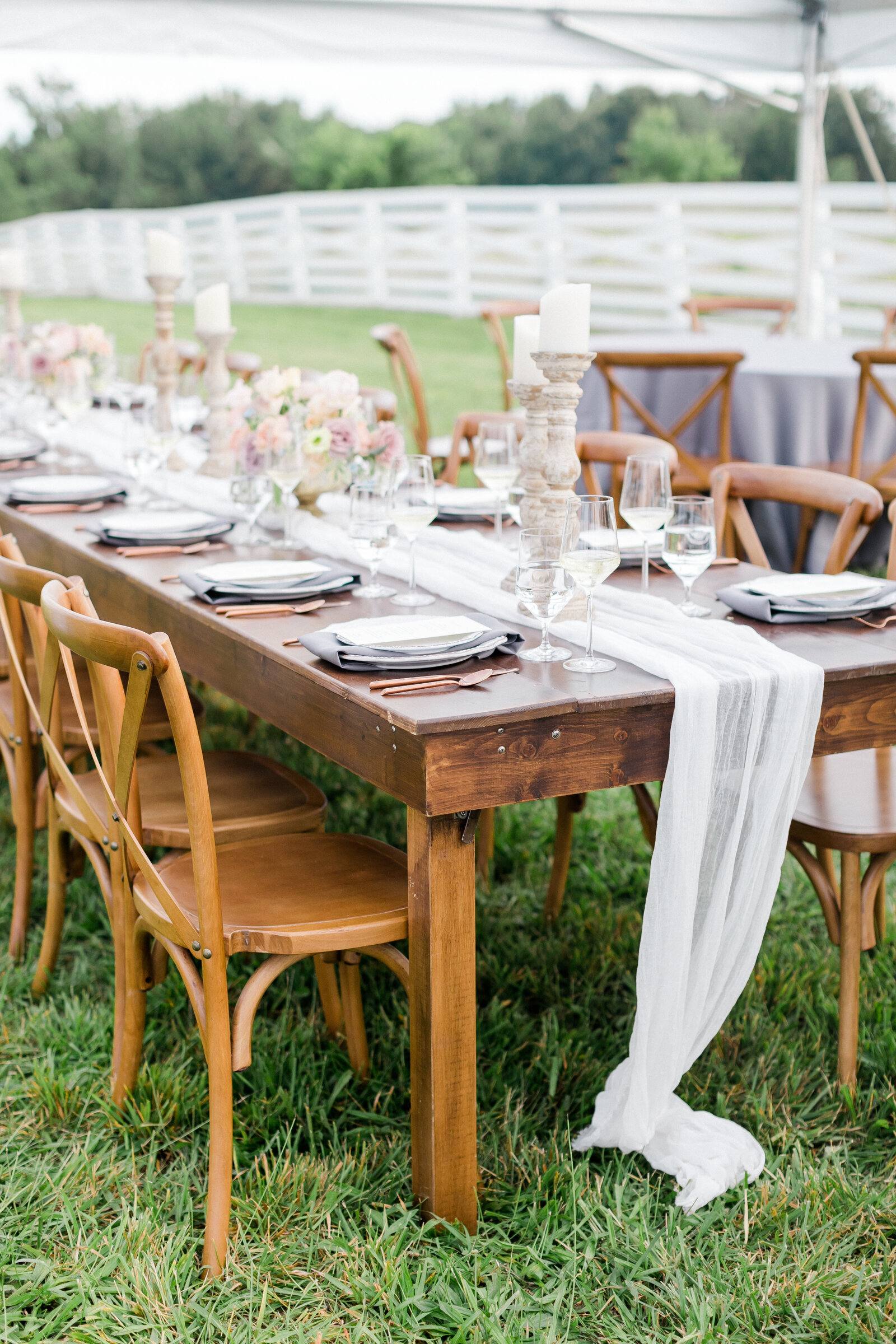 A long wooden table set for dinner on the grounds